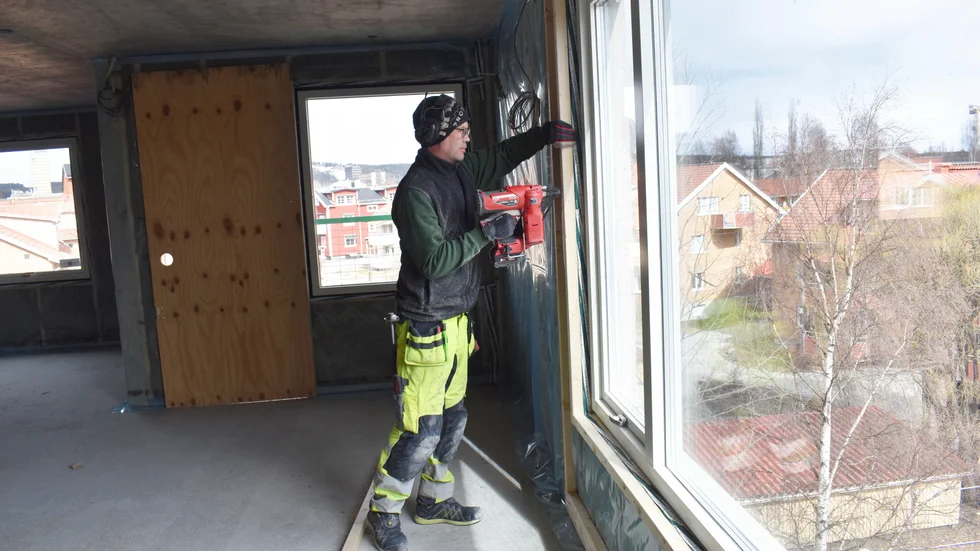 Snickare Nicklas Högkvist spikar reglar i en gaveltrea på fjärde våningen.