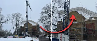 Här lyfter höga kranen upp taket på anrika byggnaden