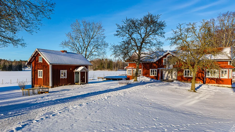 Framför den större bostaden finns två ekonomibyggnader, likt flyglar, samt ett fåtal träd med många år på nacken. 