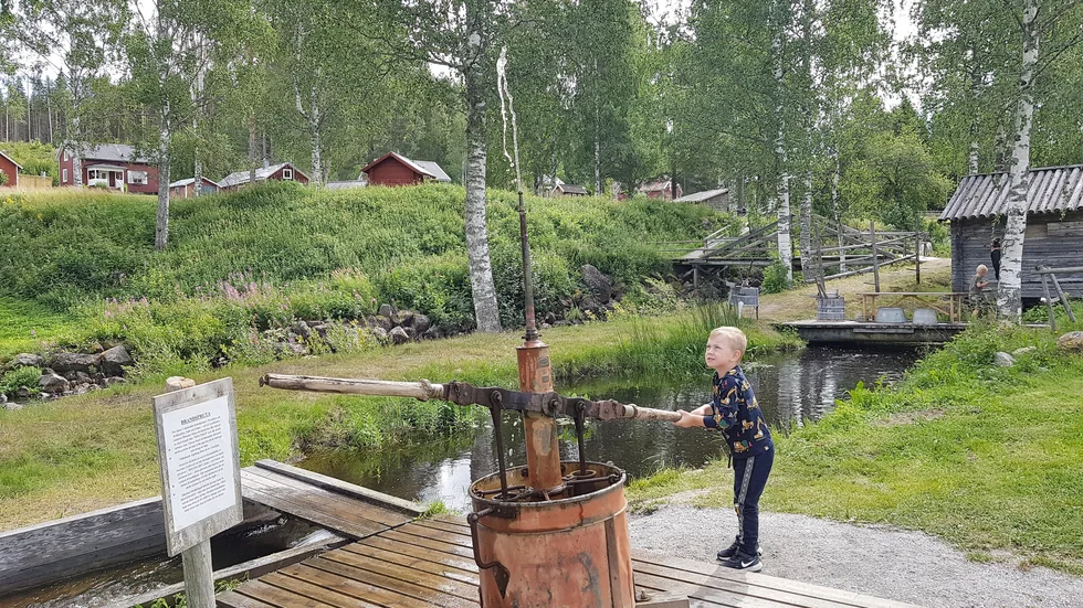 Aaron Öhman är en av många barn som vill prova spruta vatten rätt upp med den gamla brandsprutan.