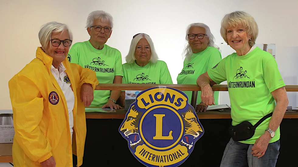 Lionskvinnorna May Gehlin, Marita Larsson, Betty Jansén, Marie-Louise Davidsson och Barbro Egir servar funktionärer med smörgås och korv.