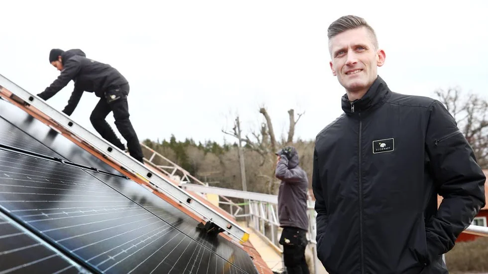 Oscar Gustavsson, vd och grundare av Ecokraft, framför montering av solcellsmoduler på ett hustak.