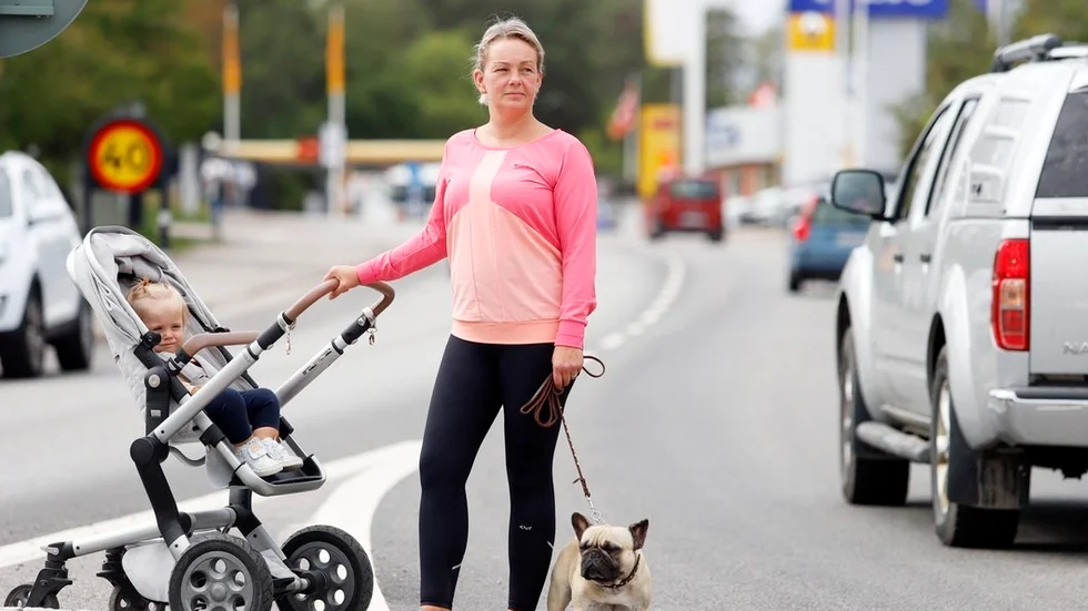 Camilla Trolle menar att Eskilstunavägen bjuder in till fortkörning av unga mopedister och förare av a-traktorer. – Det är dessa raksträckor. Man borde sätta upp farthinder eller kameror, säger hon, på bilden med hunden Helmer och ett av sina fyra barn.