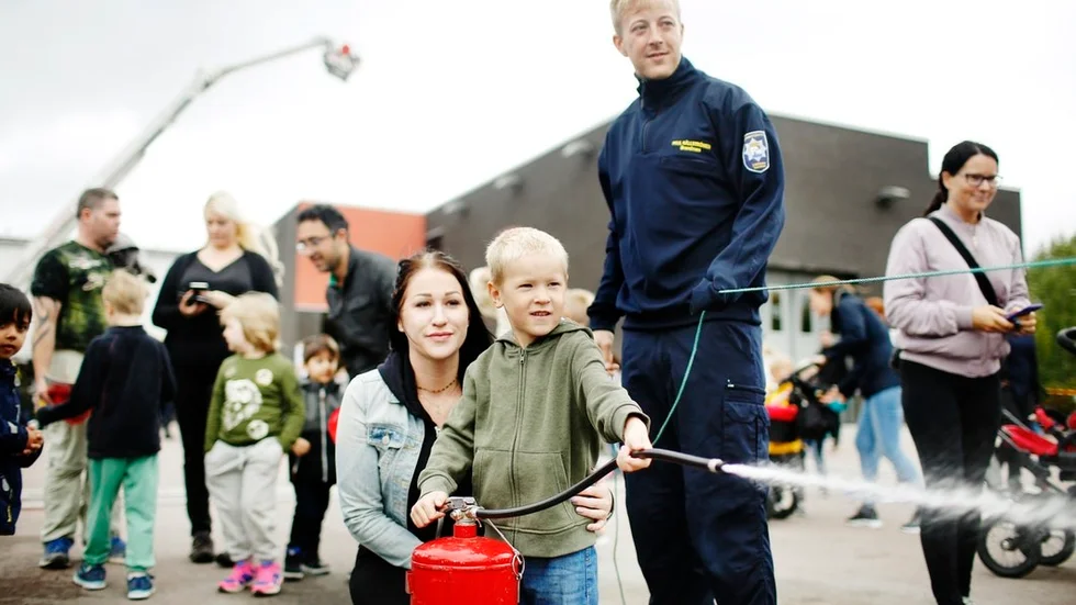 Max Karlsson var på brandstationen tillsammans med moster Madeleine Bitschnau. Här prövar han brandsprutan under brandmannen Paul Källströms överinseende.