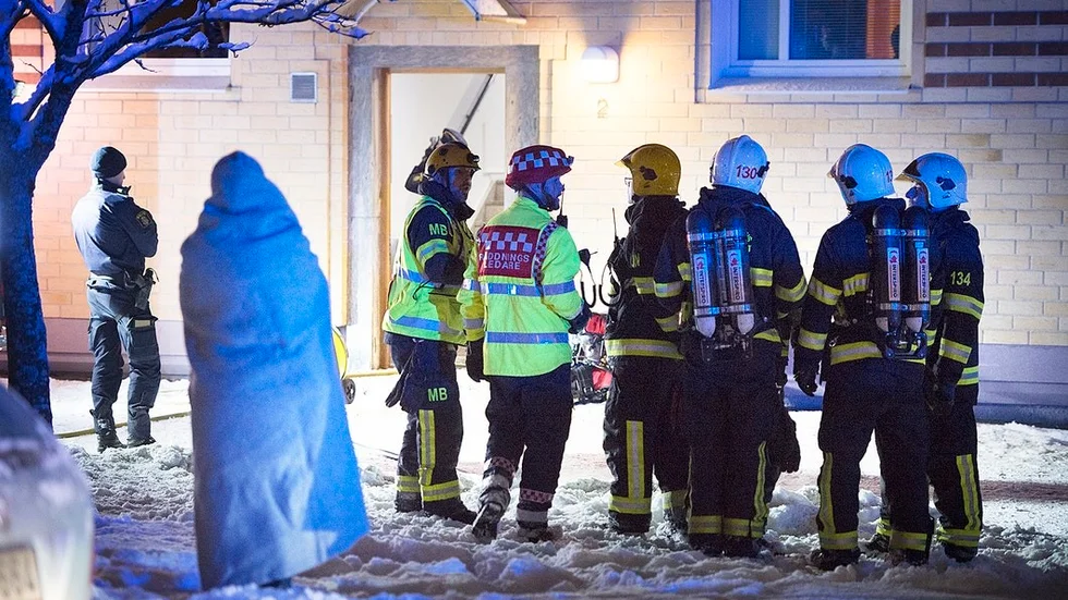 Rökdykare hjälpte ut några av de chockade boende ur det brandhärjade huset.