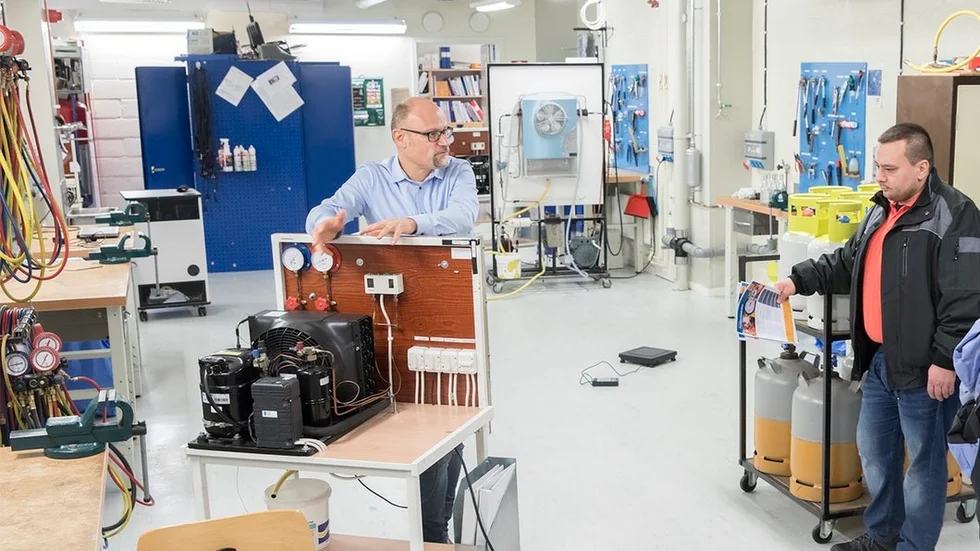Här visar ICU:s vd Marcus Andersson skolans minsta kylmaskin för Ferdi Youssein.
