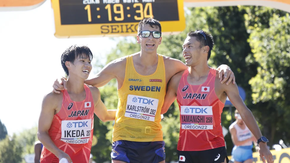 Perseus Karlström tog brons på 20 kilometer gång på friidrotts-VM i Eugene, USA. Här kramas han om av silvermedaljören Koki Ikeda och guldmedaljören Toshikazu Yamanishi direkt efter målgång.