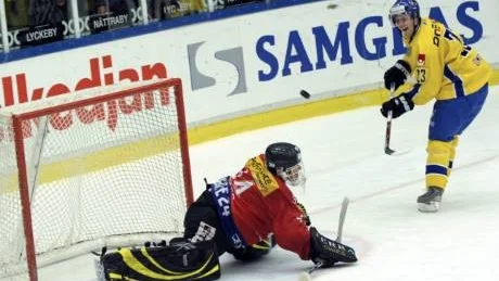 KARLSKRONA 2009-03-31 Sveriges Linus Omark flipplobbar in pucken via ribban på Marco Bührer under ishockeylandskampen mellan Sveriges Tre Kronor och Schweiz i Telenor Arena i Karlskrona på tisdagen. 
Foto: Paul Madej / SCANPIX / Kod 10390