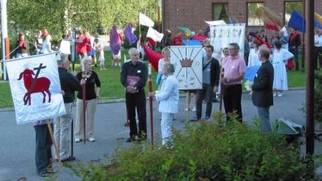 Med konungsliga banér och bibliskt färgglada flaggor samlades deltagarna i onsdagskvällens procession utanför Forum före öppningsmötet.