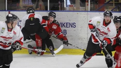 Piteå HC mötte övermäktigt motstånd i träningsmatchen mot Asplöven. Här är det Johan Risberg (i rött) som blir manglad mot sargen.