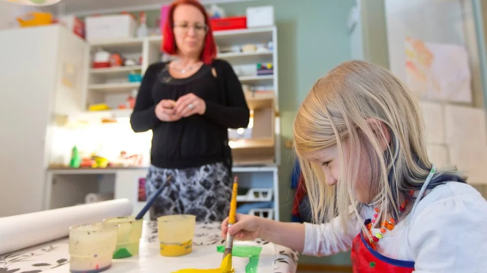 Behov. Åsa Grönlund, barnskötare och vikarie på Myrans förskola håller med sina kollegor om att arbetskläder eller ett klädbidrag skulle behövas. "Framför allt är skor man har utomhus en dyr utgift" säger hon. Målar gör Wendey Grönlund, 5 år.