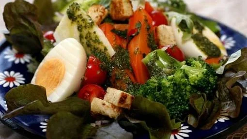 Sallad med myntamorötter, ägg, broccoli, bulgur, krutonger och caesardressing.