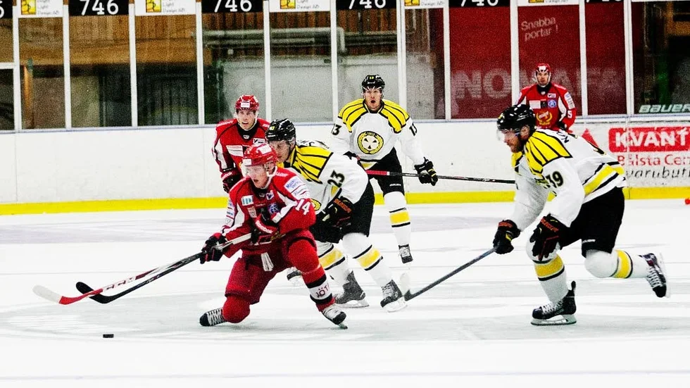 Jagad. Almtunas Sebastian Hartmann med puck. Tätt följd av flera Brynässpelare.
