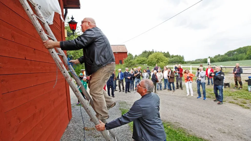 Skylt. Här tar Johan Sandin sig upp för att avtäcka tyget från den nya stationens skylt.