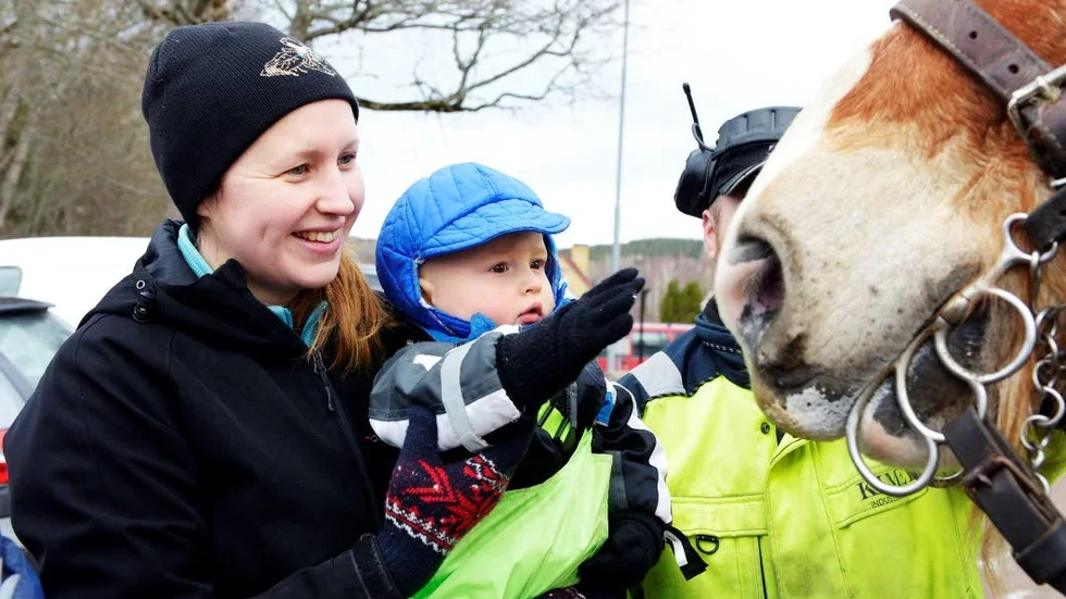Mys. Anneli Fager och Aron Fager klappar hästen Kalles mule.