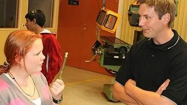 Lina Westlund frågar verkstadsläraren Henrik Johansson om råd med svarvningen. Foto: Sarah Bruze