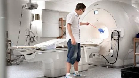 Joel Kullberg, medicine doktor och civilingenjör på Akademiska sjukhuset, visar hur stark magnetkameran är om man har metallföremål på sig.