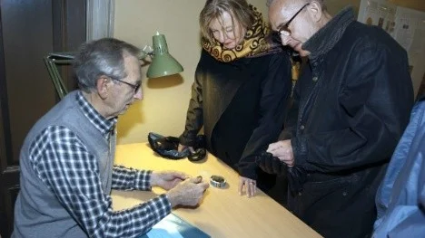 Sven-Erik Olsson granskar mynt från Lena och Matz Hannerz.