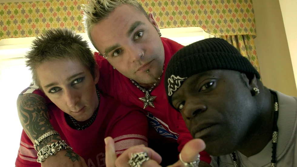 Delar av rapmetal-gruppen Crazy Town. Sångaren Shifty Shellshock i mitten. Arkivbild.