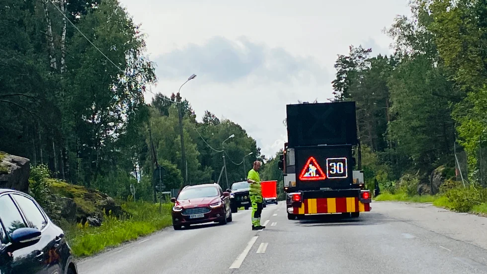 Flaggvakter reglerar trafiken på väg 53. 
