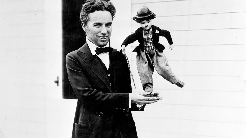 Charlie Chaplin med en docka av sin mest välkända figur.