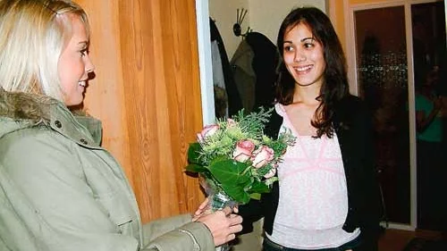 Förra årets Lucia Josefine Persson överräcker en blomsterkvast och gratulerar sin efterträdare som är 15-åriga Jenny Jonasson.