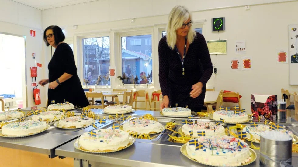 Susanne Myrgård och Pia Lindberg hjälps åt med att ställa fram tårtorna och att dekorera med flaggor och serpentiner.
