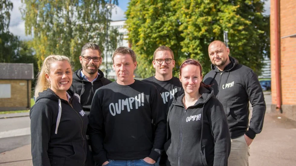 Mjölbygänget samlat. Från vänster i bild: Stina Arvidsson, Carl Montelius, Anders Carlborg, Peter Enmark, Nathalie Lindblom och Djani Skrgo utanför kontoret på Kanikegatan. Företaget har även anställda som arbetar i Stockholm. Produktionen av oumph sker på en anläggning i Stora Levene i Vara kommun.