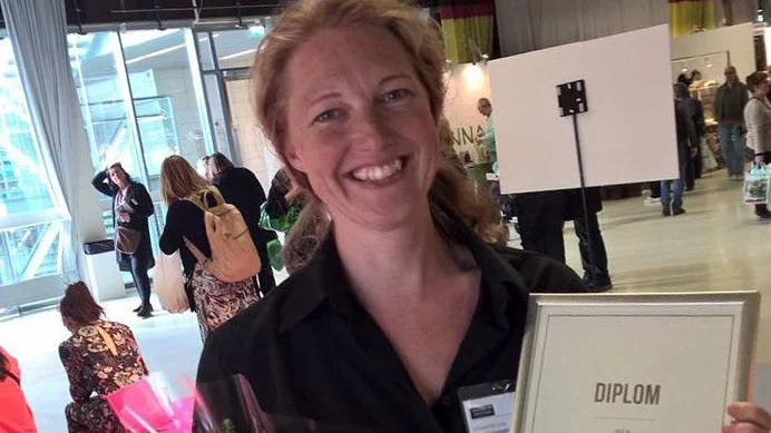 Karin Eliasson, konstnärlig ledare och trädgårdsmästare på Astrid Lindgrens Näs, med diplomet i högst hugg.