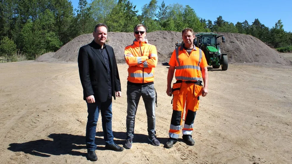 Magnus Ribbing och Stefan Wass från gatukontoret och entreprenören Pelle Ekström framför berget av uppsopad sandningssand.