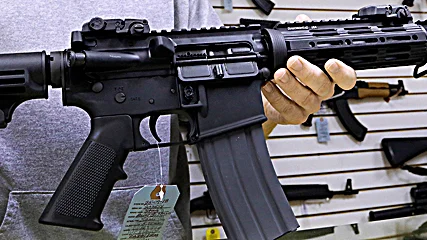 John Jackson, co-owner of Capitol City Arms Supply shows off an AR-15 assault rifle for sale Wednesday, Jan. 16, 2013 at his business in Springfield, Ill. President Barack Obama launched the most sweeping effort to curb U.S. gun violence in nearly two decades, announcing a $500 million package that sets up a fight with Congress over bans on military-style assault weapons and high-capacity ammunition magazines just a month after a shooting in Connecticut killed 20 school children. (AP Photo/Seth Perlman)