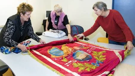 Margaretha Lindbäck, Ann-Marie Nordström och Gunhild Larsson är rädda om sin hundraåriga fana.                        FOTO: Bengt-Åke Persson