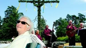 Njuter av sommaren. Gun Bååt bor på Tjustgården och njuter av att få komma ut på midsommarfirande och träffa de andra som bor här. Att få lyssna på musik är ju heller inte dumt och här underhåller Västerviks Glapack.Foto: Elin Lundholm