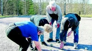 Viktig mätning. Ulla Johansson kollar med måttband vilket klot som är närmast "lillen". Inger Andersson, Åke Johansson och Hans Karlsson är med vid kontrollen.