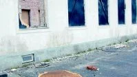 Nerrivet. De skivor som satts upp för fönstren är borta på flera ställen, eller som här nerrivna och ligger på backen.