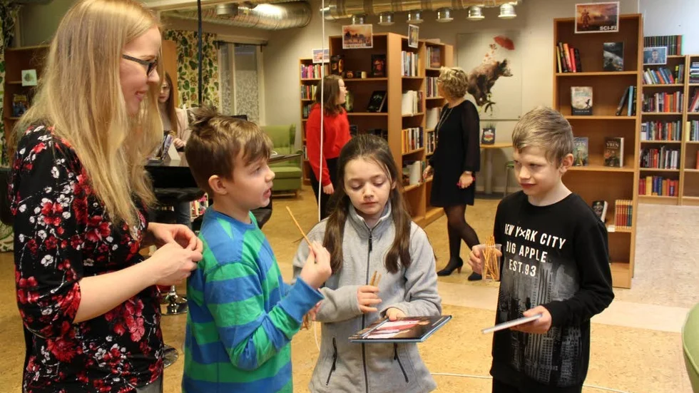 Samspråk. Nyhemsskolans skolbibliotekarie Sofie Larsson i samspråk med några av skolans elever.