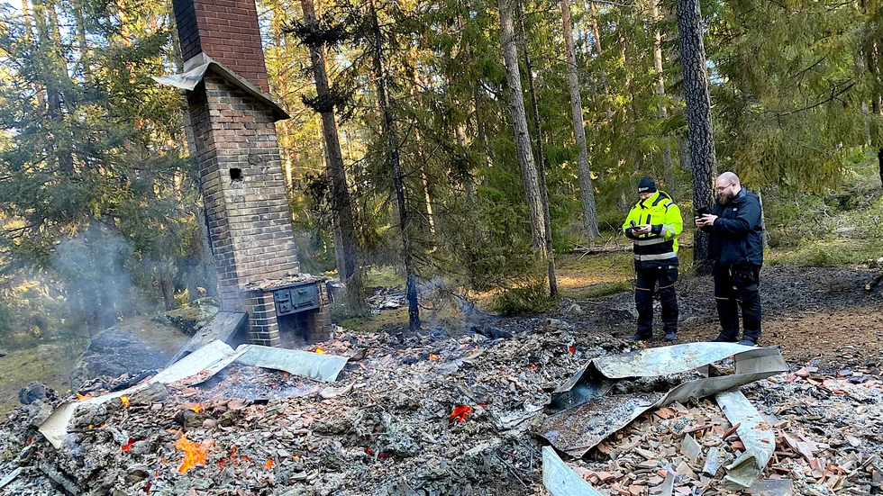 Två mindre hus vid grillplatsen vid elljusspåret i Grillby brann ned till grunden natten till fredag. Nicklas Högsberg och Marcus Nilsson från kommunens fastighetskontor inspekterar förödelsen. En äldre vedspis fanns i stugan men om den kan ligga bakom branden eller om branden var anlagd är oklart.