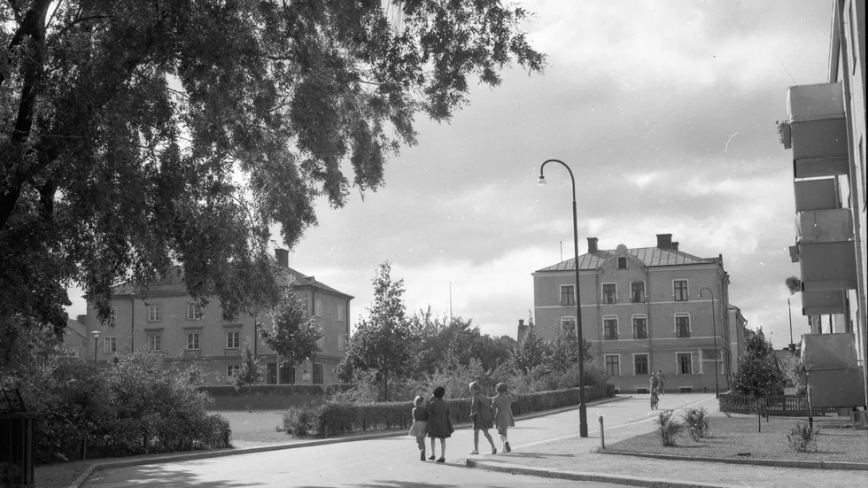 15 september 1950. Linköping. Flickor på väg till eller från skolan korsar Västanågatan i riktning mot Sandrinoparken. Huset till vänster på Västra Vägen finns kvar än i dag. Huset intill revs och ersattes av ett parkeringshus som i sin tur återigen har fått ge plats åt ett bostadshus.