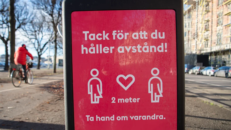 En skylt på en soptunna på Strandvägen i centrala Stockholm uppmanar människor att hålla avstånd. Arkivbild.