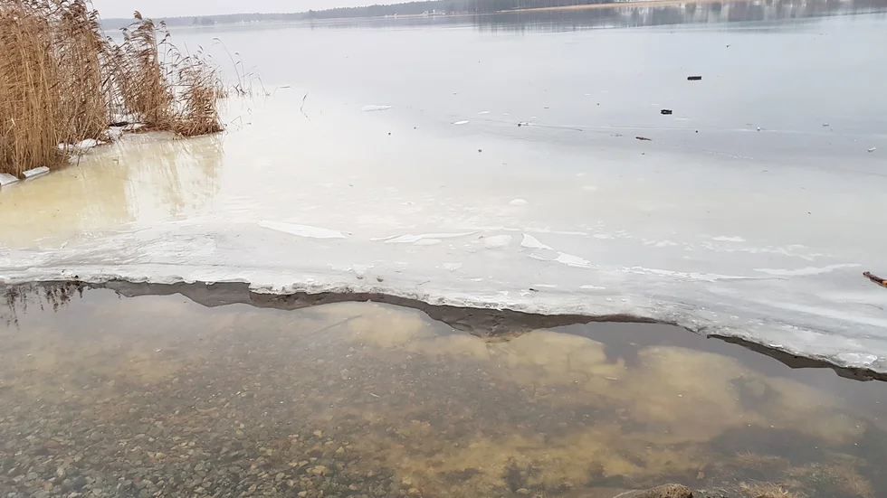 Isen ligger blank som en spegel vid Norrstrand. Men det är svårt att ta sig ut för den som vågar, på grund av öppet vatten vid land.