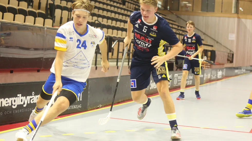 Unge Kasper Rodlert i Visby IBK jagar bollen. Bakom syns målskytten John Pettersson.