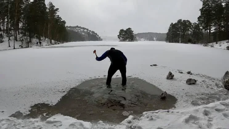 Rickard Segh slog hål på isen vid Krampans badplats med hjälp av en yxa som han fick låna av löparkompisen Tobias Andersson.