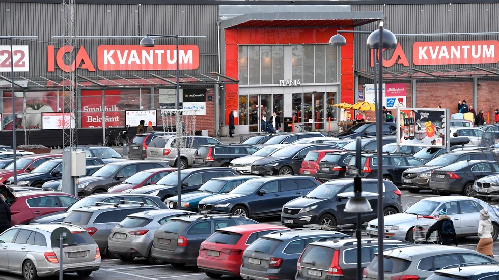 Fullt med bilar på parkeringsplats vid köpcenter. Arkivbild.