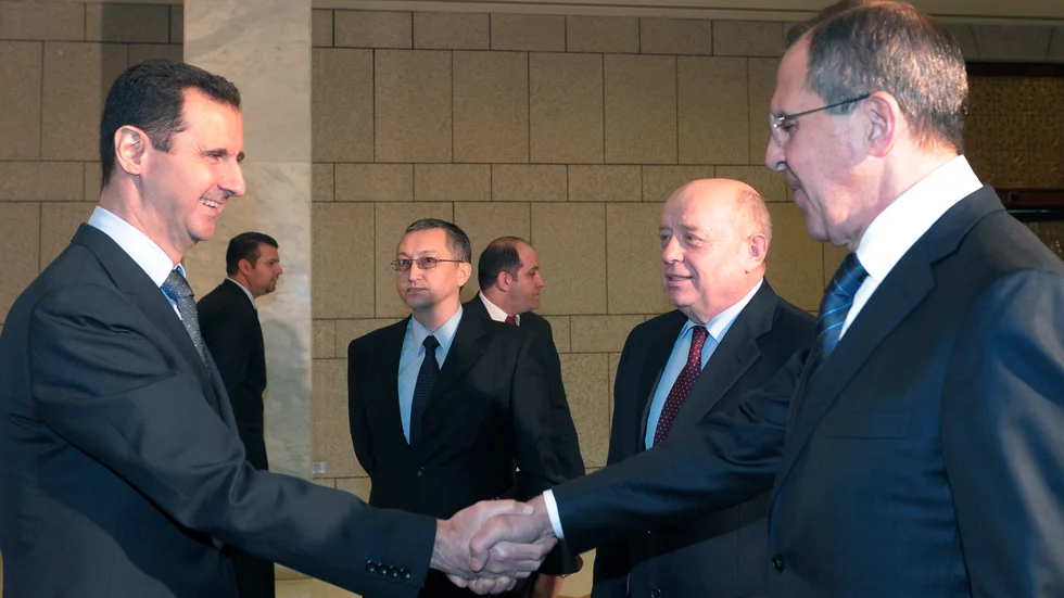 Syriens president Bashar al-Assad, till vänster, skakar hand med Rysslands utrikesminister Sergej Lavrov under den senares besök i Syrien den 7 februari 2012. Arkivbild.
