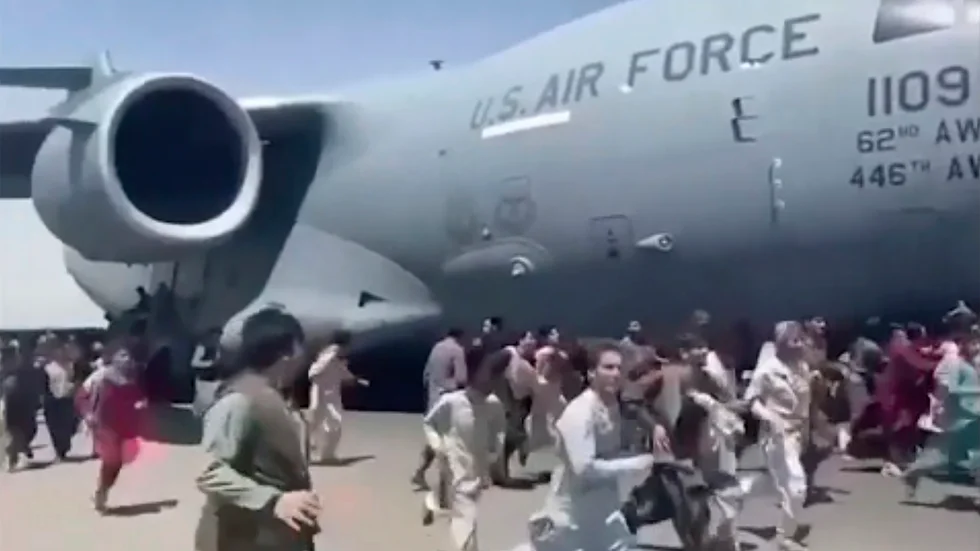 Civila afghanser försöker fly från talibanerna genom att klamra sig fast vid lyftande flygplan.
