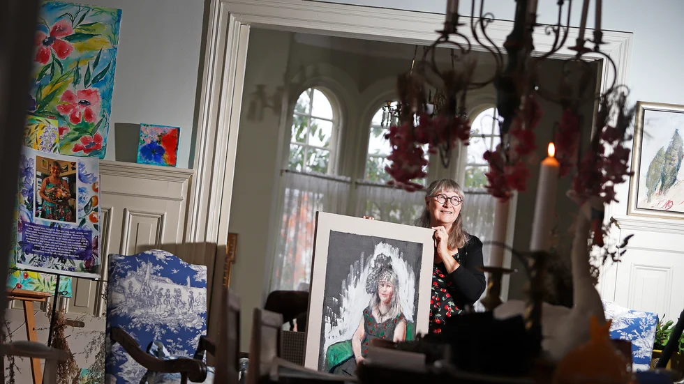 Lena Linderholm i stora salongen med ett porträtt av sig själv som nyligen målades av konstnären Maura Tavares.