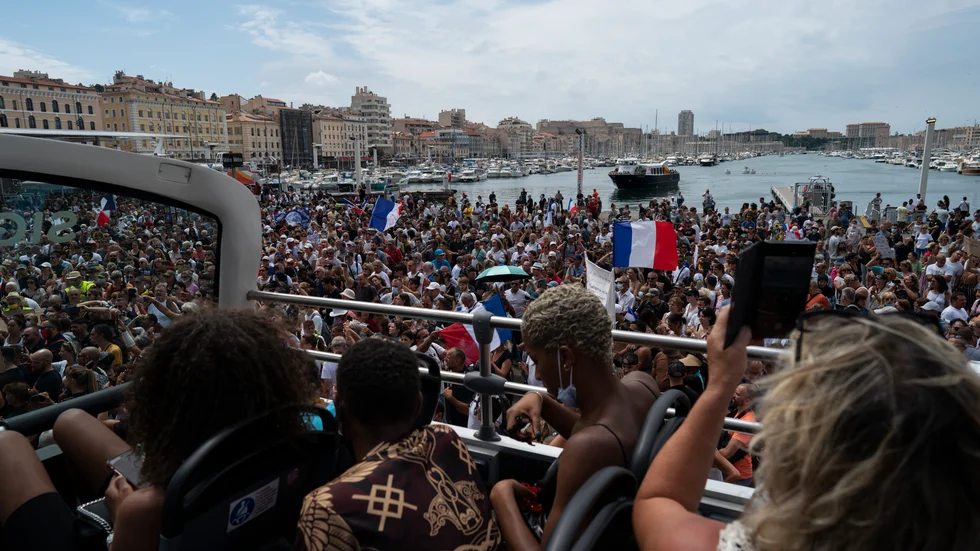 Turister bevittnar protester mot de utvidgade reglerna om covidpass i Marseille i lördags.