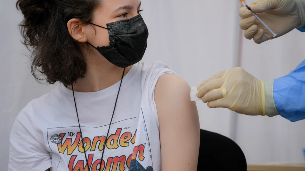 En flicka får Biontechs och Pfizers vaccin mot covid-19 i Rumänien, som är ett av de länder som har börjat vaccinera tonåringar.
