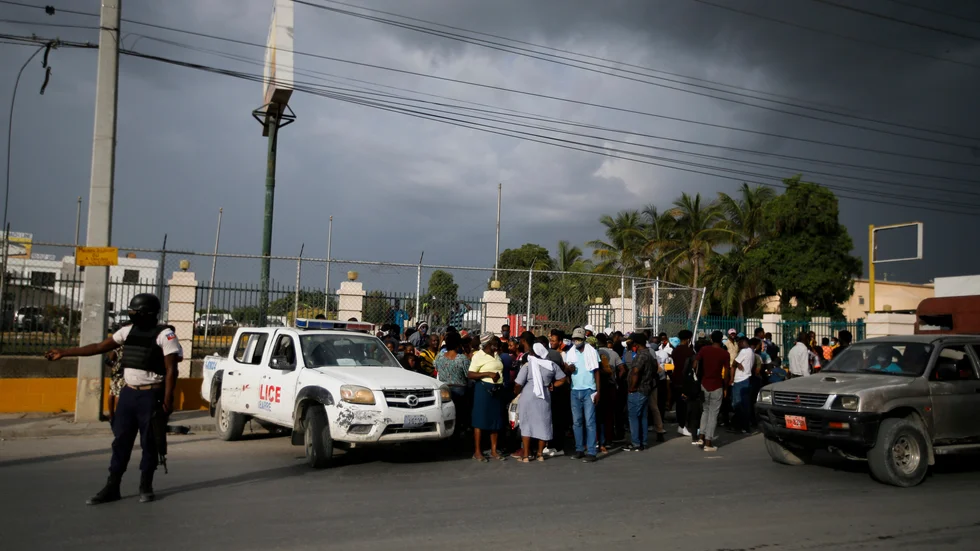 Haitisk polis stoppar folkmassor utanför USA:s ambassad i huvudstaden Port-au-Prince.