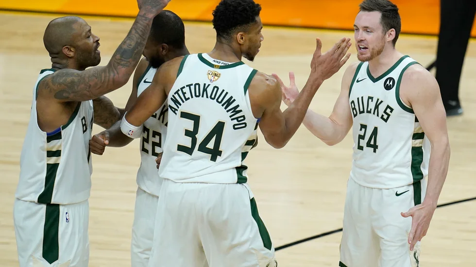 Milwaukees P.J. Tucker (vänster) firar med Khris Middleton, Giannis Antetokounmpo och Pat Connaughton under den femte finalmatchen mot Phoenix.